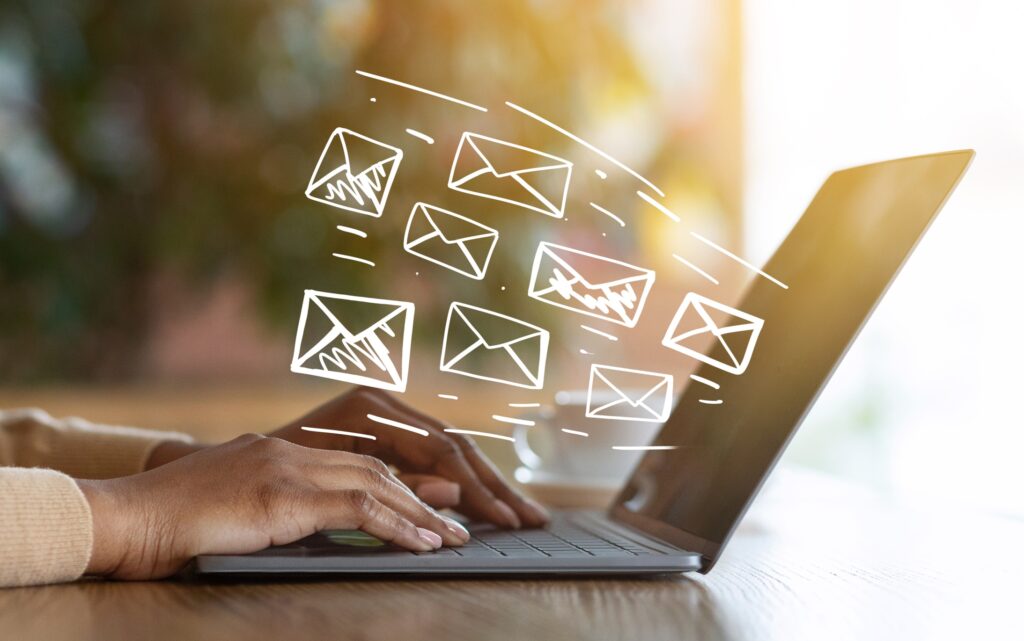 Lead generation concept: marketing emails fly from a laptop screen.