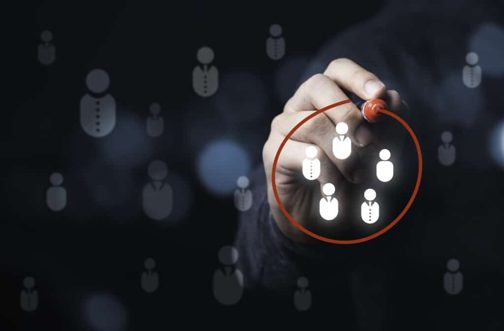 A marketer draws a red line around a group of white, illuminated icons representing leads.
