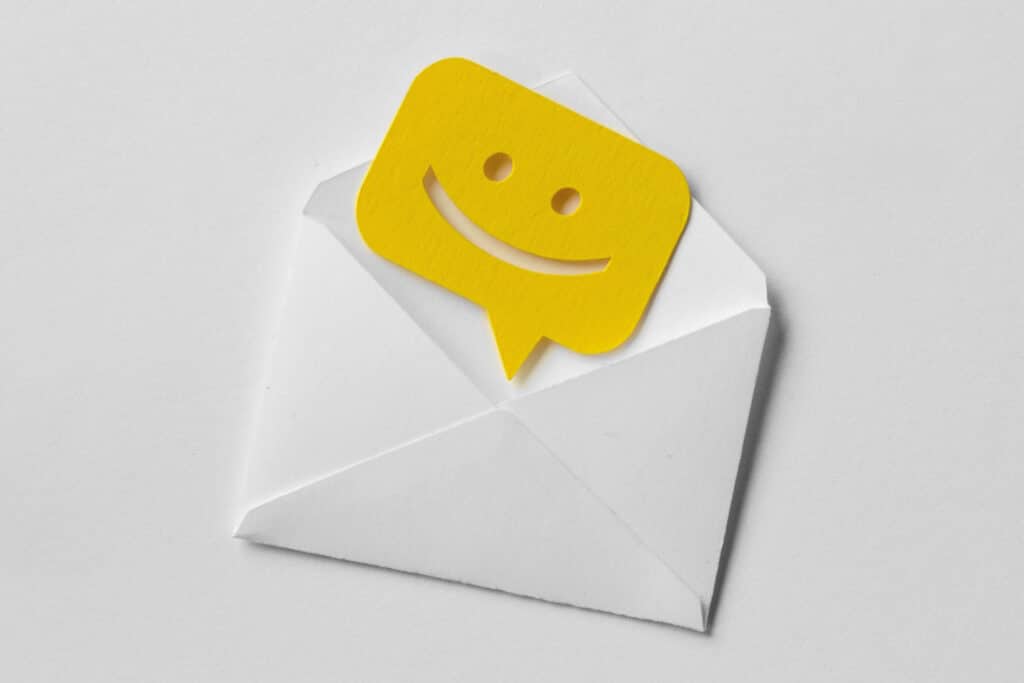 Email envelope with smiling message bubble on white background.