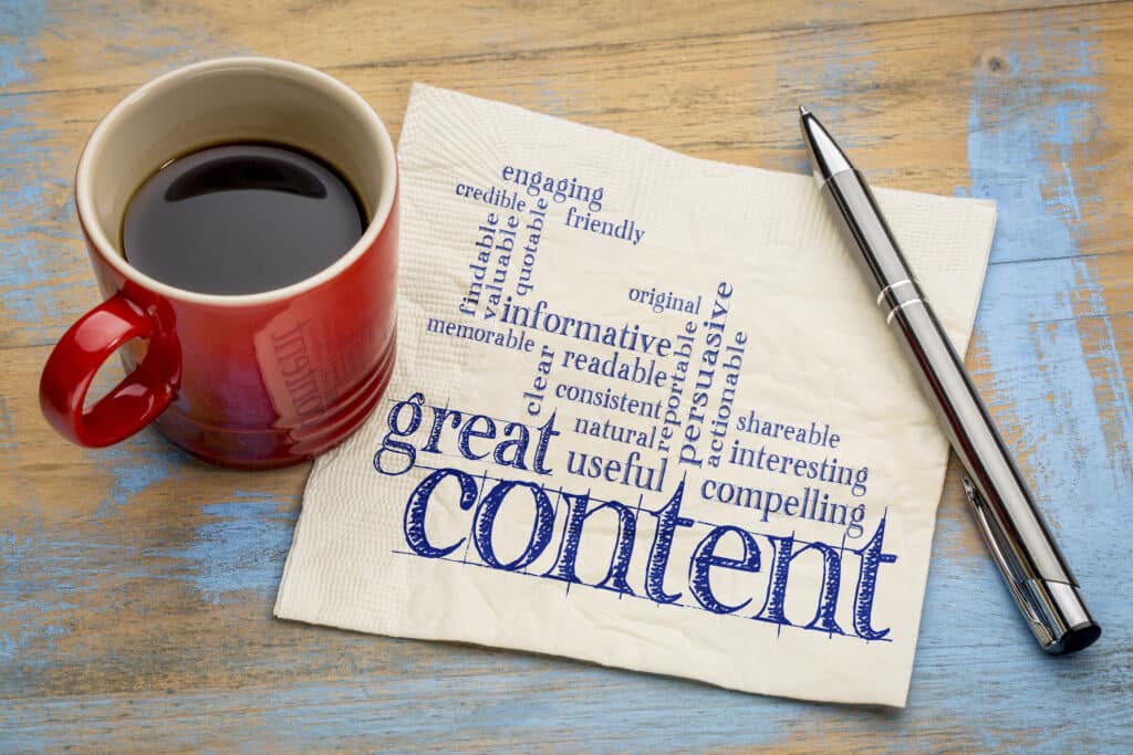 A word cloud of adjectives describing "great content" are written on a napkin, beside a cup of coffee and a pen.