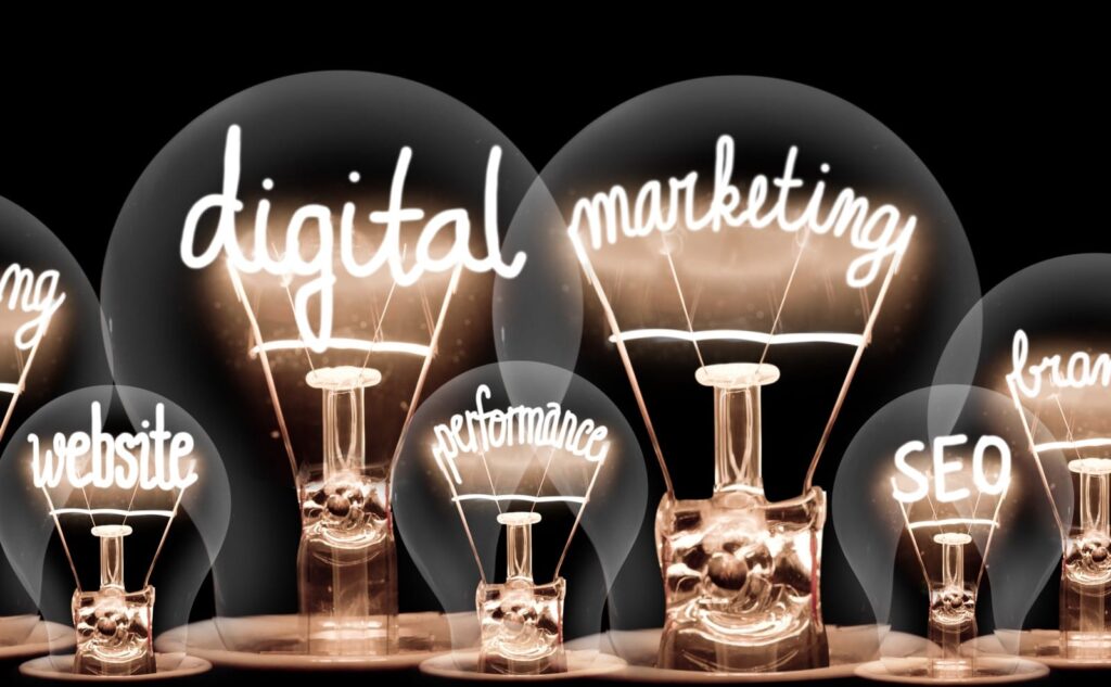 Digital Marketing Strategy concept: clear lightbulbs have shining fibers in the shape of words, including "digital," "marketing," "website," "SEO," "performance," and "brand."