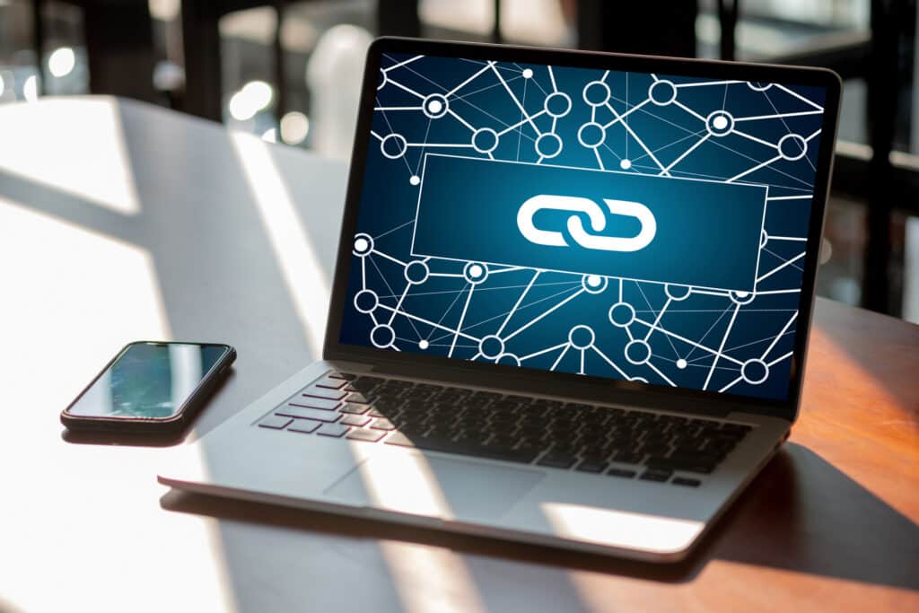 Backlinks concept: a laptop screen displays a large landing page link icon over a web of interconnected points.