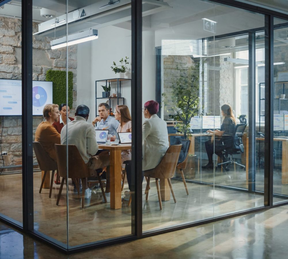 Diverse Group of Professional Businesspeople Meeting in the Modern Office Conference Room. Creative Team Discuss App Design, Analyze Data, Plan Marketing Strategy, Disrupt Social Media, Growth Hack